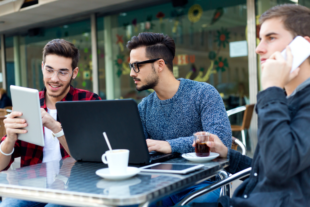 Jovens sentados em uma mesa de café com laptops: um símbolo do empreendedorismo digital
